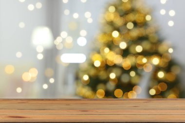 Boş ahşap masa, bulanık odaya karşı, Noel ağacı ve ışık var. Tasarım için boşluk