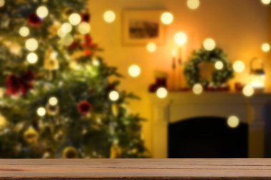 Boş ahşap masa, bulanık odaya karşı, Noel ağacı ve ışık var. Tasarım için boşluk