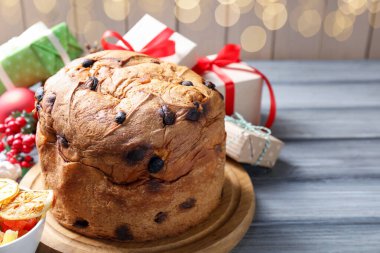 Lezzetli bir Noel pastası ve gri ahşap masada hediye kutuları. Metin için boşluk