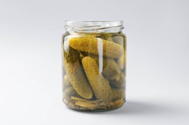 Hafif arka planda kavanozda salatalık turşusu, yakın plan.