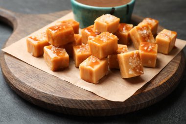 Koyu dokulu masada tuz ve karamel soslu lezzetli şekerler, yakın plan.