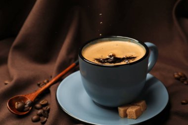 Kumaşa aromatik kahve, fasulye ve esmer şeker dök, yakın çekim.