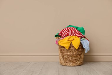 Çamaşır sepetinin yanında bej duvar, metin için yer var.