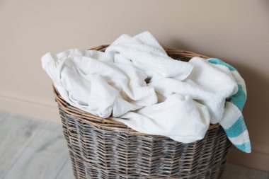 Çamaşır sepetinin yanında bej duvar var, yakın plan.