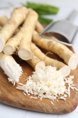 Izgara yaban turpu, rende ve taze kökler beyaz masada, yakın plan.