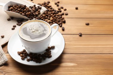 Aromatik kahve fincanda, fasulye de ahşap masada, yakın plan. Metin için boşluk