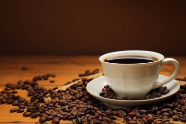 Aromatik kahve fincanda, fasulye de ahşap masada, yakın plan. Metin için boşluk