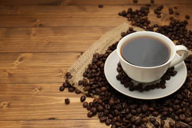 Aromatik kahve fincanda, fasulye de ahşap masada, yakın plan. Metin için boşluk