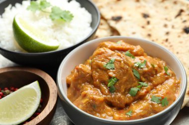 Lezzetli tavuk tikka masala, kişniş, pirinç, limon ve biber tabakta, yakın plan.