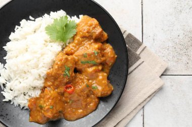 Pirinçli tavuk tikka masala, açık fayanslı masa, üst manzara.