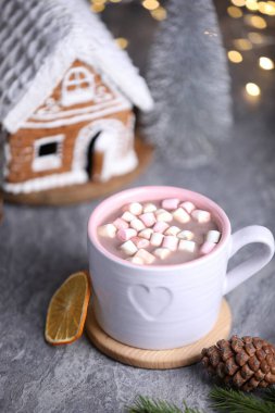 Gri masada lokum ve Noel dekoru olan lezzetli kakao bulanık ışıklara karşı, yakın plan.