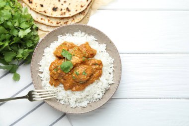 Pirinçli tavuk tikka masala, beyaz ahşap masada kişniş ve lavaş, düz yatak. Metin için boşluk