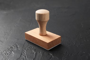 Koyu desenli bir masa üzerinde ahşap bir damga, yakın plan.