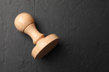 Koyu desenli bir masa üzerinde ahşap bir damga, üst manzara. Metin için boşluk