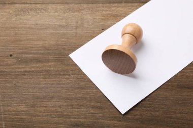 Masada bir tahta pul ve boş bir kağıt tabaka, üst manzara. Metin için boşluk