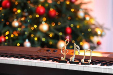 Piyano ve Noel ağacı üzerine altın notalar, yazı için yer. Bokeh etkisi