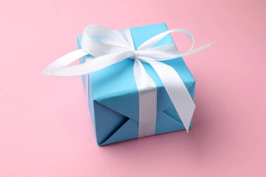 Pembe arka planda güzel bir hediye kutusu, yakın plan.