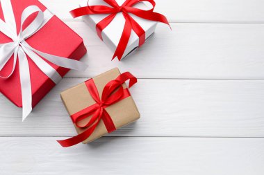 Beyaz ahşap arka planda güzel hediye kutuları, düz yatış. Metin için boşluk