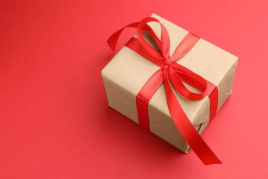 Kırmızı arka planda güzel bir hediye kutusu, yakın plan. Metin için boşluk