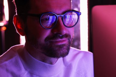 Gözlüklü bir adam. Kapalı mekanda yansıyor. Yakın plan.