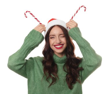 Beyaz arka planda Noel Baba şapkası ve baston şekerleri olan güzel bir kadın. Noel sezonu