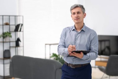 Gayrimenkul değerlendirmesi. Evdeki mülkiyet değerlendirmesini yürüten pano ile müfettiş, metin için boşluk