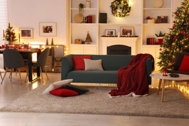 Noel ağacı, kanepe, şömine ve şenlikli dekorlu şık bir oda. İç tasarım