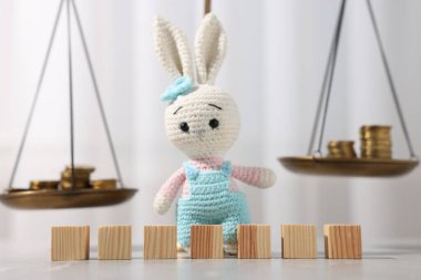 Nafaka. Boş küpler, oyuncak tavşanlar, gri mermer masa üzerindeki pullar ve paralar, yakın plan.