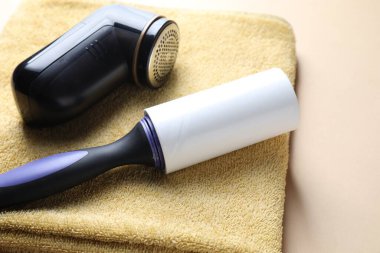 Lint silindiri, kumaş traş makinesi ve bej arka planda havlu, yakın plan.