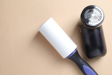 Bej arka planda pamuk tutacağı ve kumaş traş makinesi, düz konum. Metin için boşluk