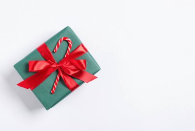 Beyaz arka planda baston şekerle süslenmiş Noel hediyesi, üst manzara. Metin için boşluk