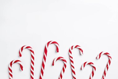 Mutlu Noeller ve mutlu yıllar. Beyaz arka planda şeker kamışları, düz yatış. Metin için boşluk