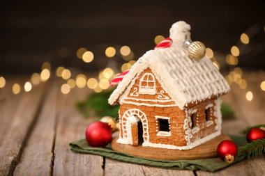 Güzel zencefilli kurabiye evi ve ahşap masa üzerindeki süsler bulanık ışıklara karşı, yazı için yer ile yakın çekim. Noel hediyesi