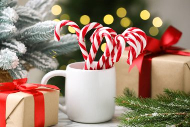 Bardakta şeker kamışı ve masada bulanık ışıklara karşı Noel dekoru, yakın çekim