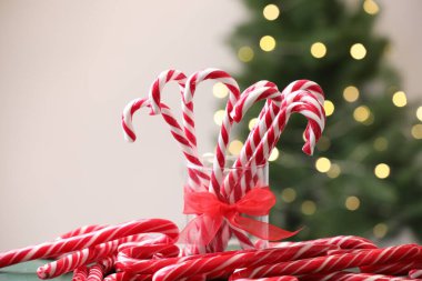 Masadaki şeker çubukları bulanık ışıklara karşı, yakın plan. Noel hediyesi