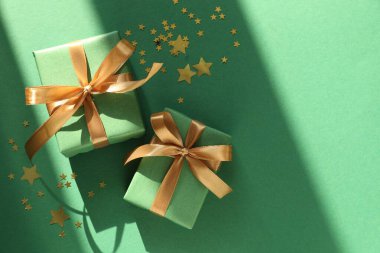 Yeşil arka planda hediyeleri ve dekorasyonu olan güzel bir Noel kompozisyonu. Metin için boşluk