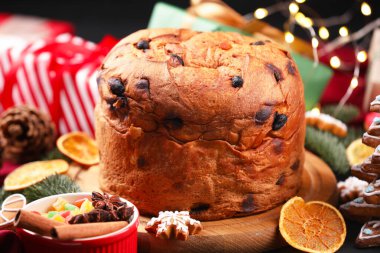Lezzetli panettone keki, zencefilli kurabiye, baharatlar, şekerli meyveler ve Noel süsü, yakın plan.