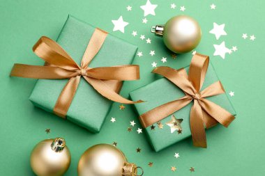 Yeşil arka planda hediyeler ve dekorlarla güzel bir Noel kompozisyonu.