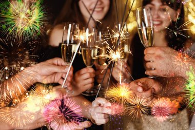 Mutlu yıllar 2026 tebrik kartı. Maytap ve şarap kadehleriyle kutlama yapan arkadaşlar.