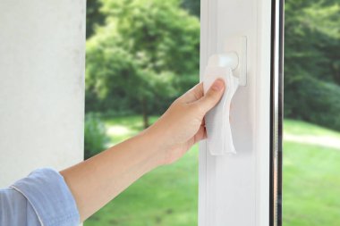 Pencereyi temizleyen kadın, yakın çekim. Yeşil bahçe, camdan manzara