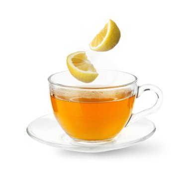 Citrus içeceği sağlık desteği için. Limon parçaları beyaz arka planda bardağa düşüyor. Soğuk mevsim ilacı