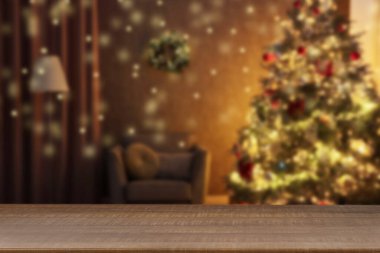 Boş ahşap masa, bulanık odaya karşı, Noel ağacı ve ışık var. Tasarım için boşluk