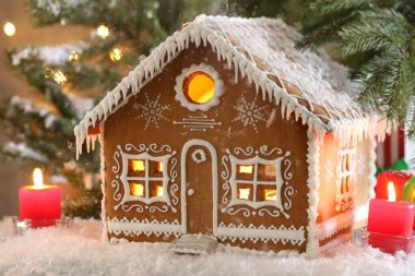 Güzel zencefilli kurabiye evi ve Noel dekoru masada, yakın plan.