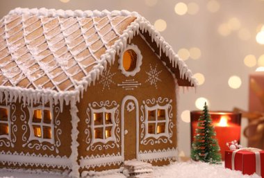 Güzel zencefilli kurabiye evi ve Noel dekoru bulanık ışıklara karşı, yakın plan