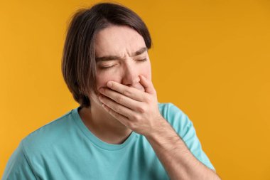 Sarı arka planda bulantı çeken bir adam. Metin için boşluk