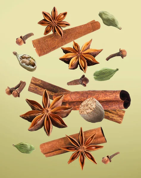 Açık yeşil arka planda düşen Noel baharatları