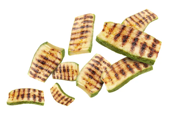 Izgara kabak parçaları beyaz arka planda havada uçuşuyor.