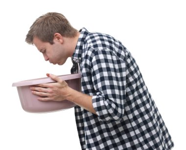 Beyaz arka planda mide bulantısı çeken genç bir adam.