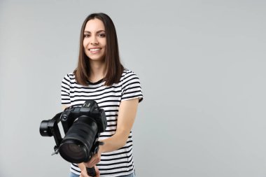 Kameraman, arka planında kamera olan titreşimli dengeleyici kullanıyor. Metin için boşluk