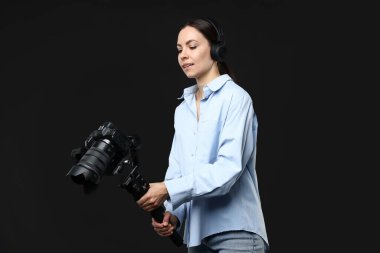 Siyah zemin üzerinde kamera olan titreşimli dengeleyici kullanan kameraman